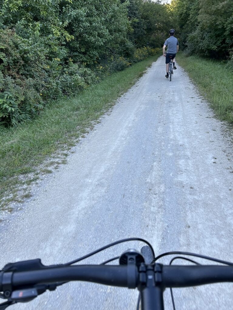 Two bikers are seen from a view on the trail.