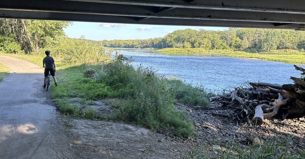 A person looks out over a blue water river.