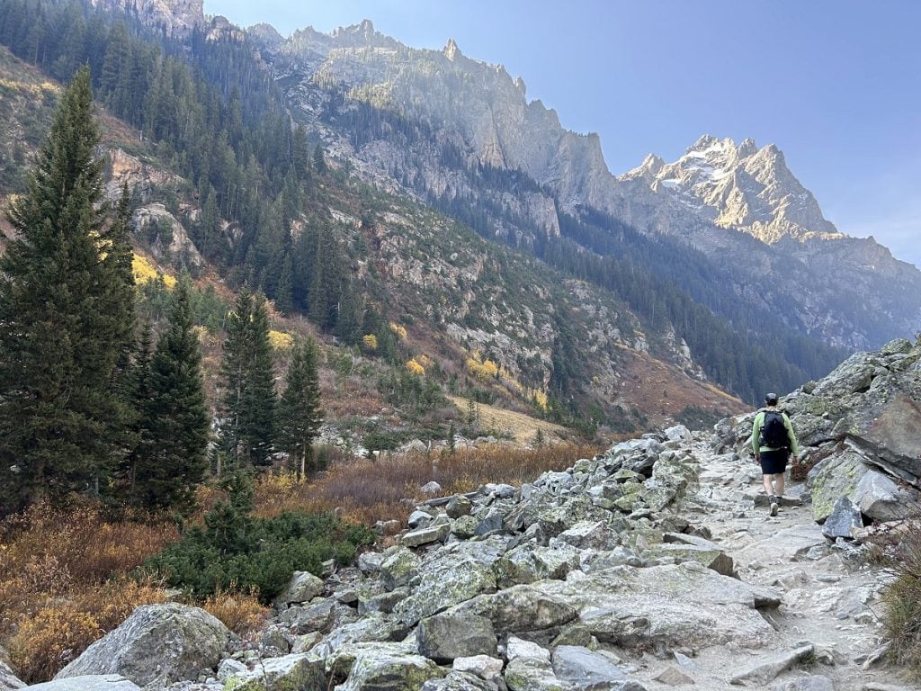 A scene from the trail shows mountains and fall leaves changing colors.