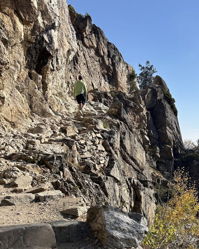 A man hikes up some rough looking bluffs.