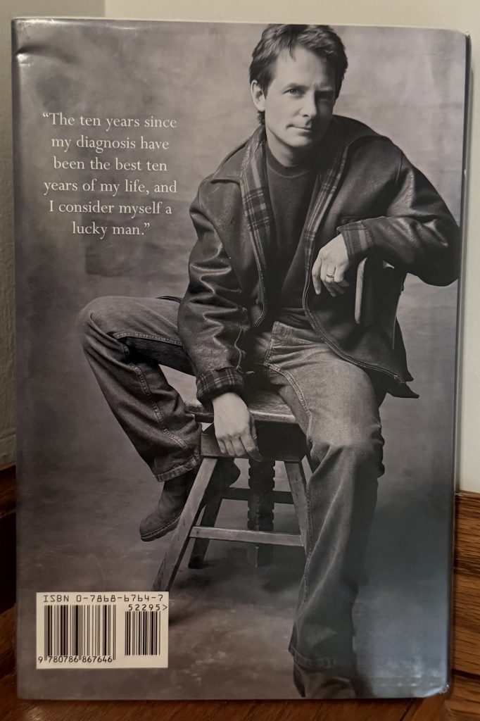 The back cover of "Lucky Man" has Fox sitting casually on a stool.