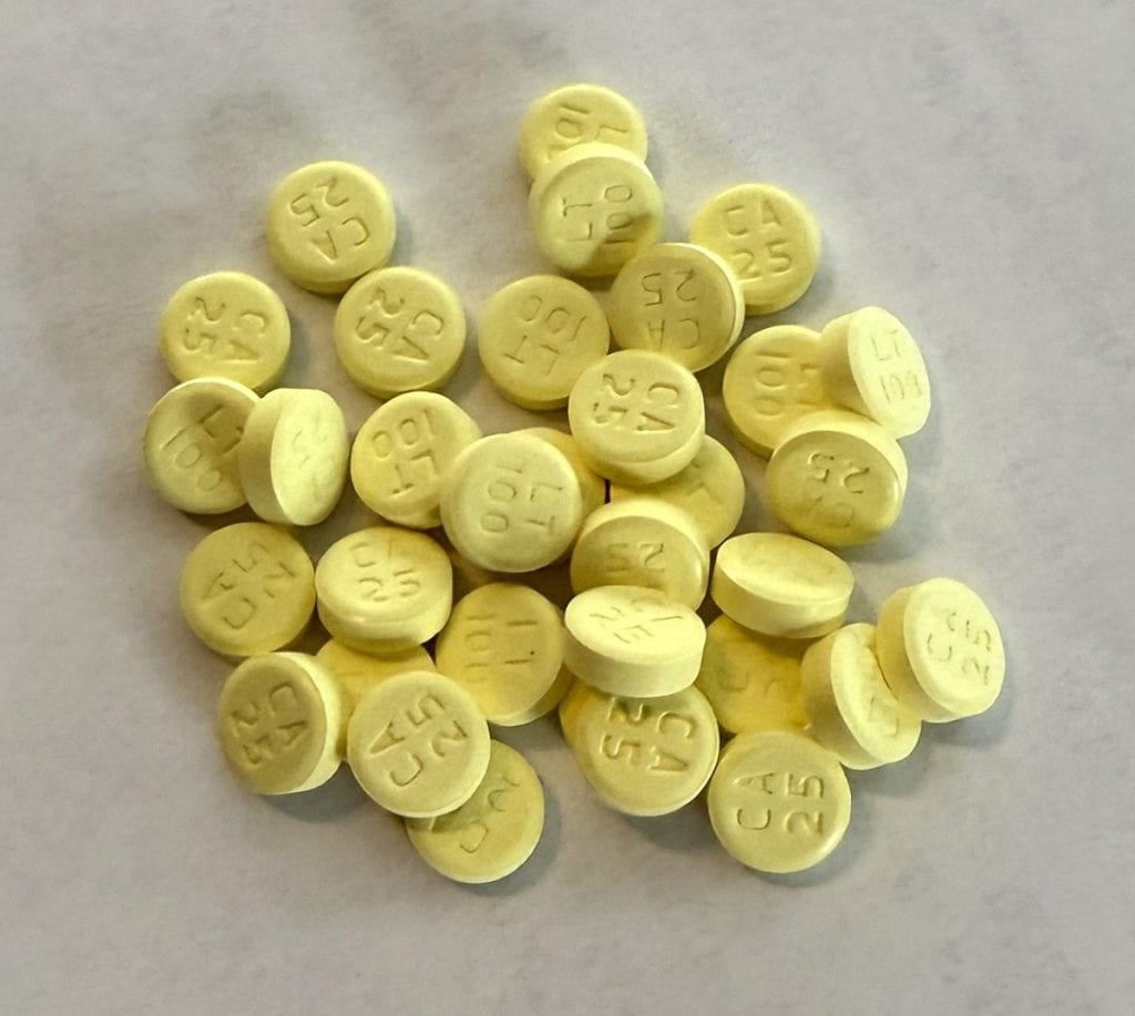 A pile of yellow pills is shown.