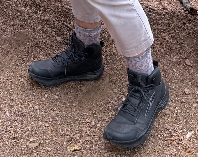 A pair of new black boots are shown up to the wearer's shins.