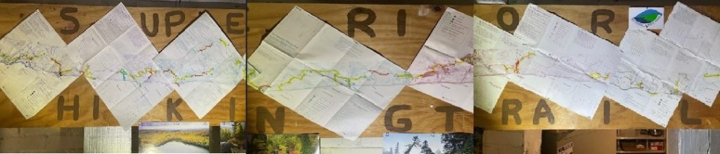 A long bunch of maps are pinned on a wall.