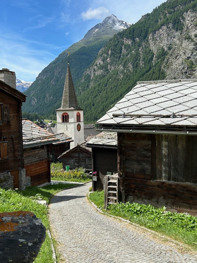 A quaint town shows narrow streets leading to a church steeple.