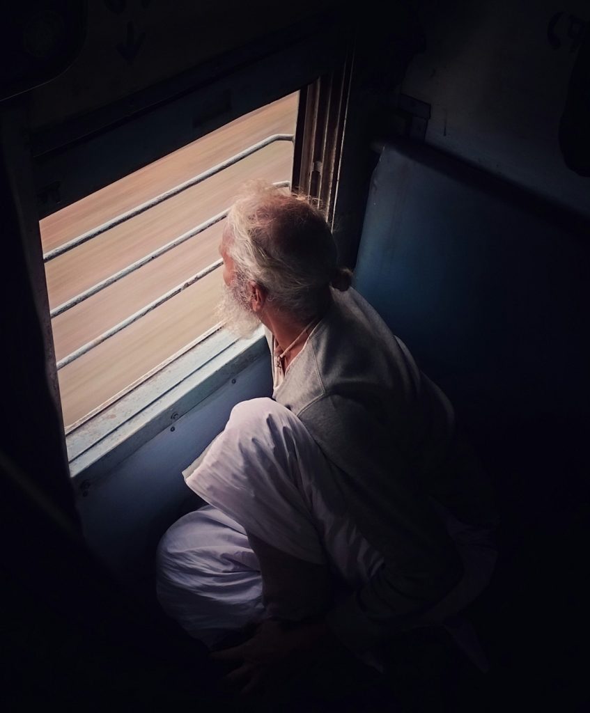 A person looks out the window of a bus.
