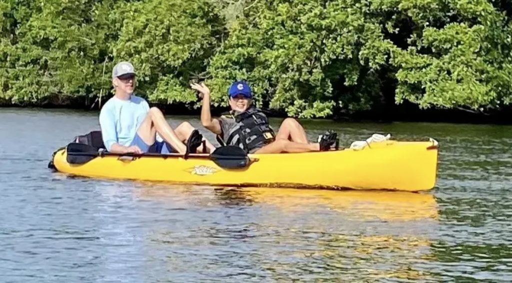 Two people enjoy a ride in a yellow kayak.