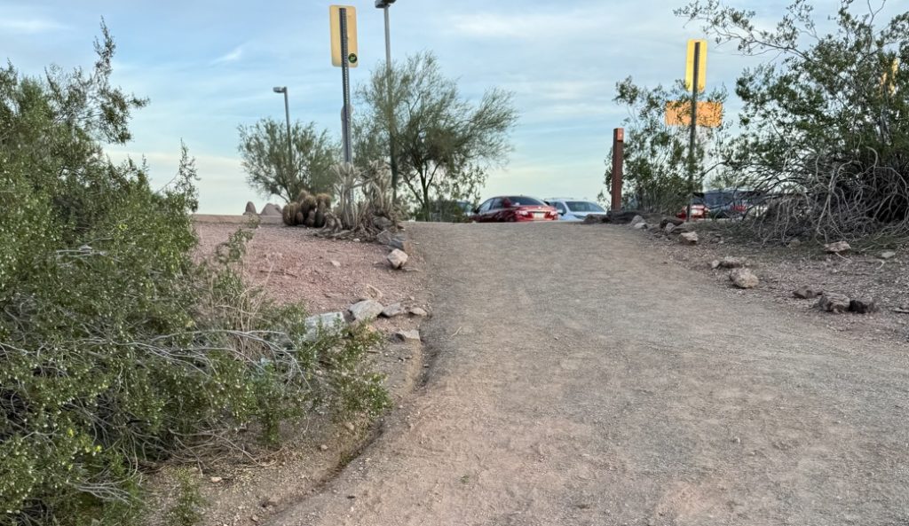 A smooth path goes up a few feet ending at a parking lot.