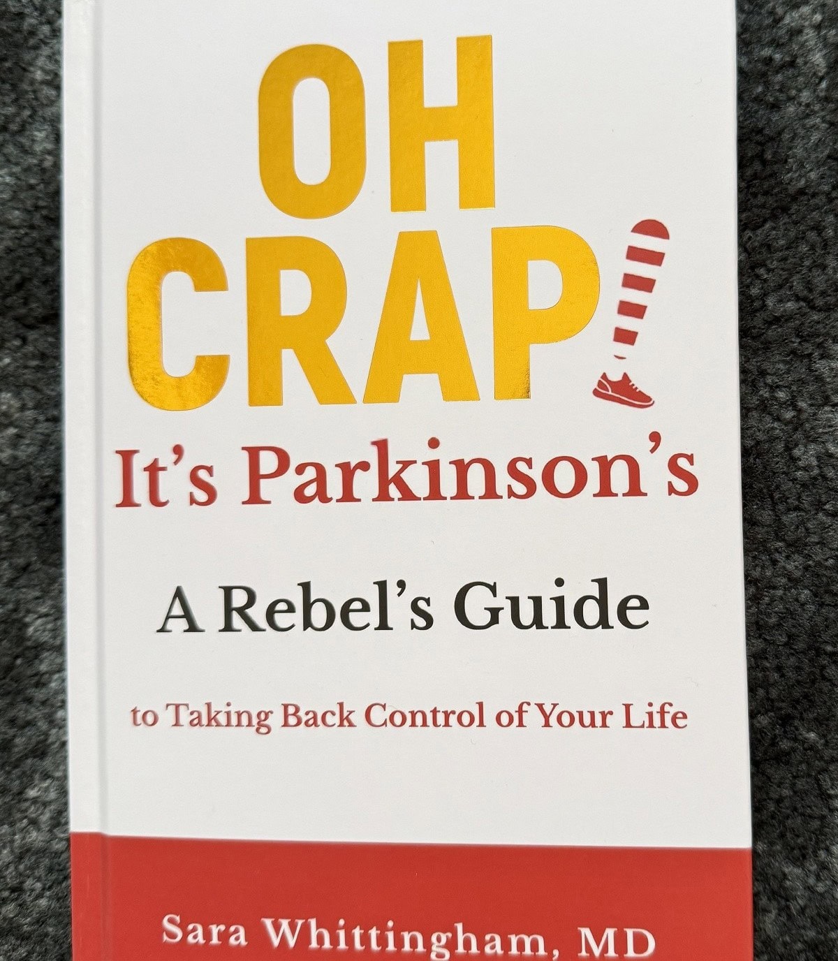 A book with the title "Oh Crap" It's Parkinson's is shown.