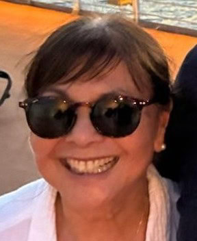 A woman with sunglasses on smiles.