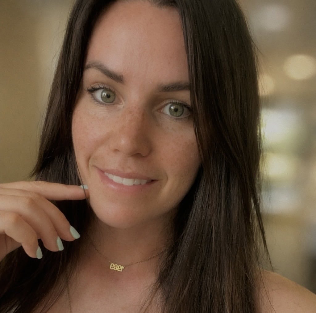A young woman with long hair smiles at the camera.