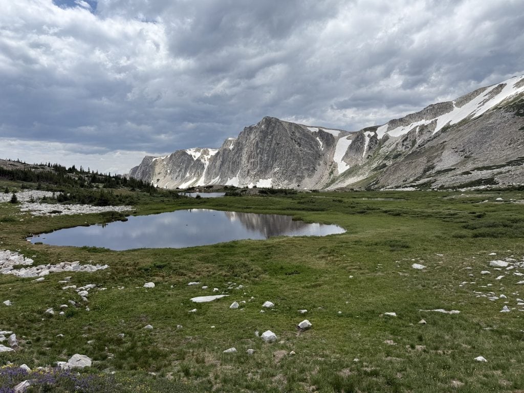 A gray lake is shown backed by gray mountains.
