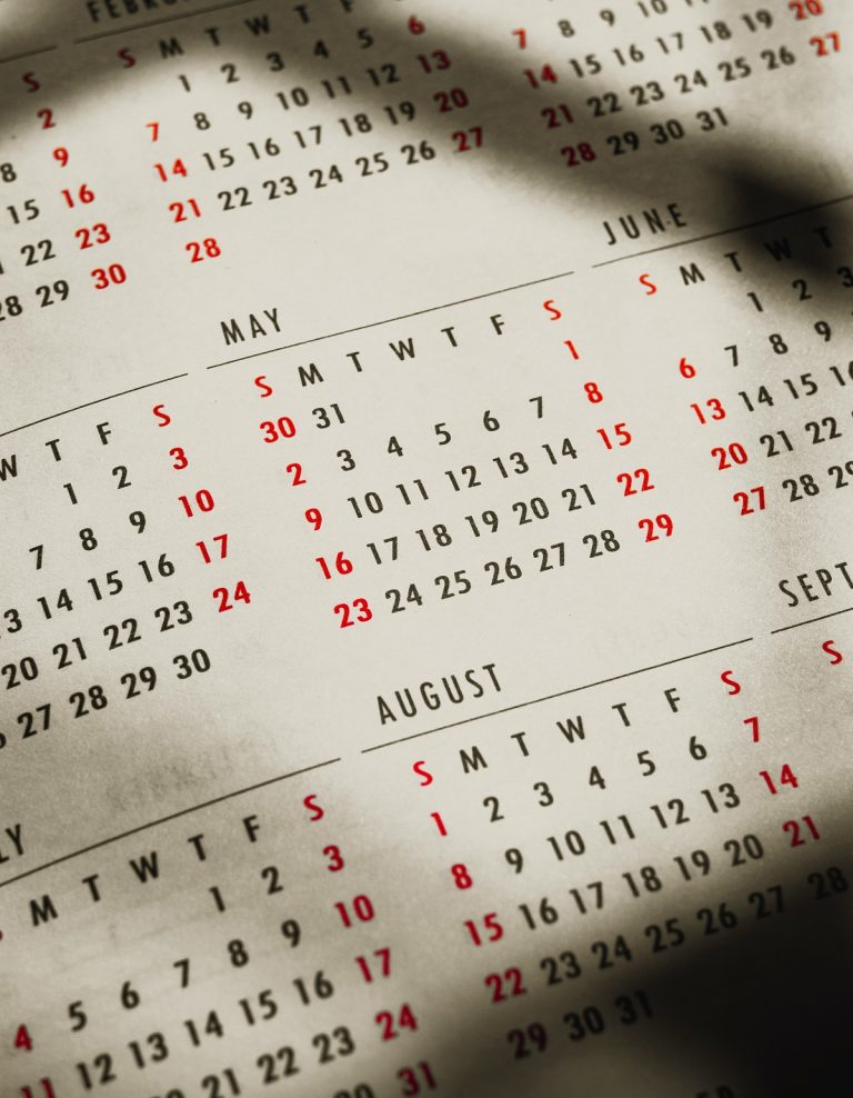 A closeup of a calendar shows different months.