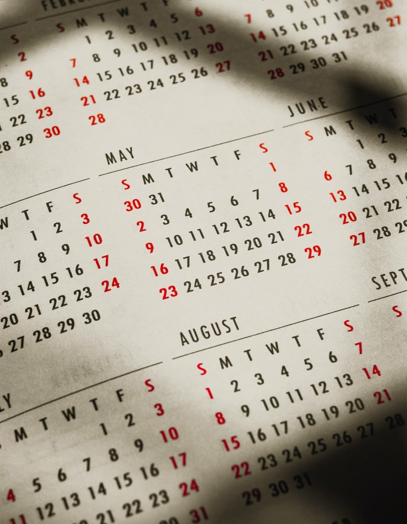 A closeup of a calendar shows different months.