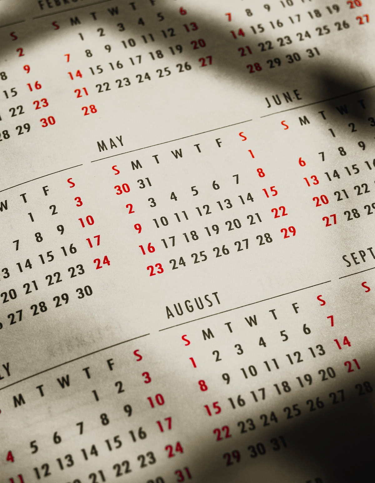 A closeup of a calendar shows different months.