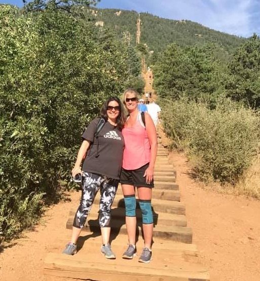 Two woman stand on the Manatou Incline, where thousands of setps go up a hill.
