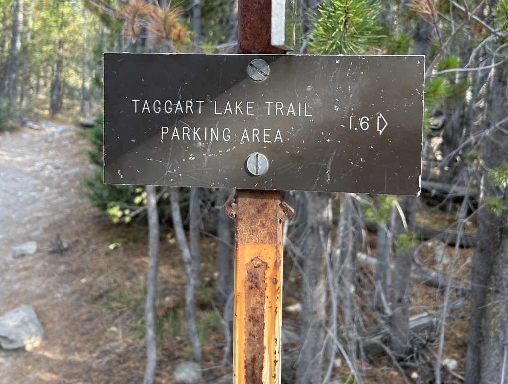A sign has an arrow with the words "parking lot."