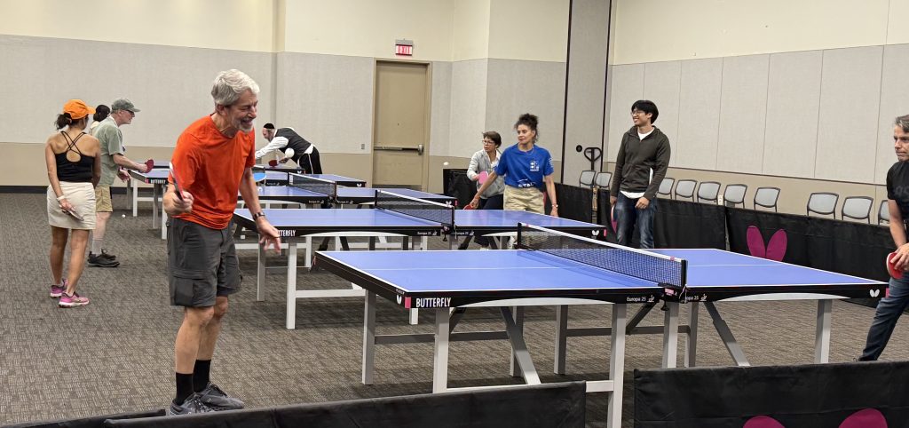 Many tables are set up for ping pong players.