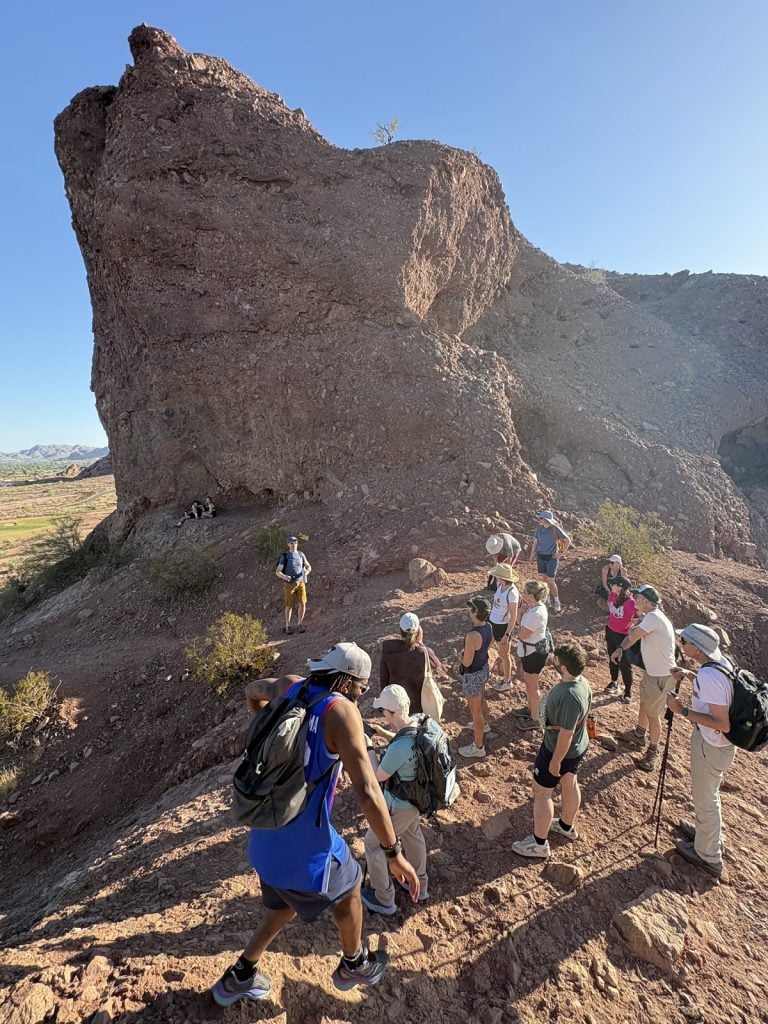 Hikers are seen from above walking over a rocky surface.