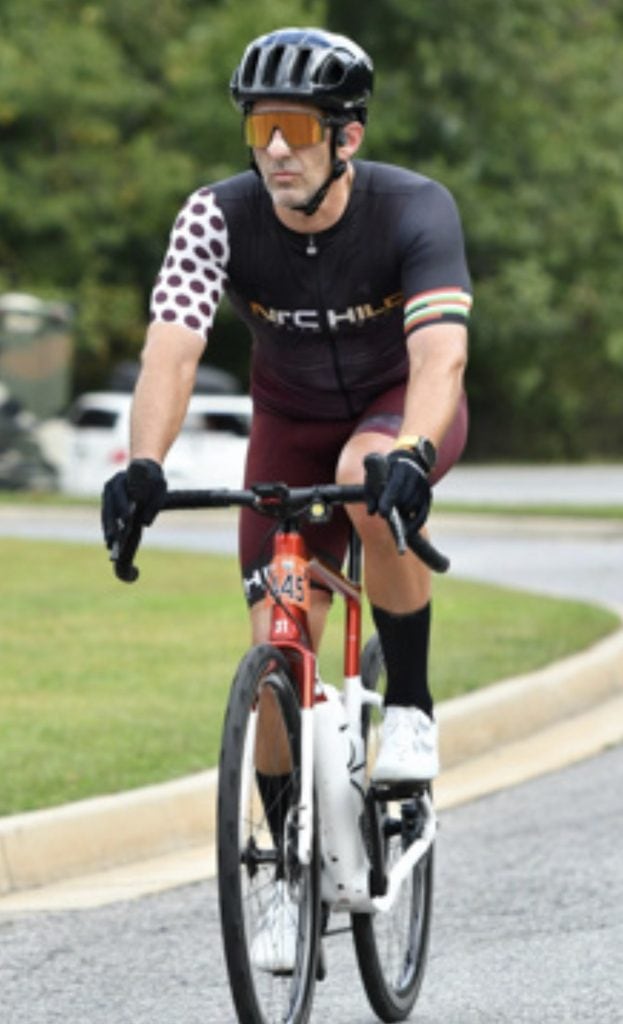 A man on a road is bicyling.