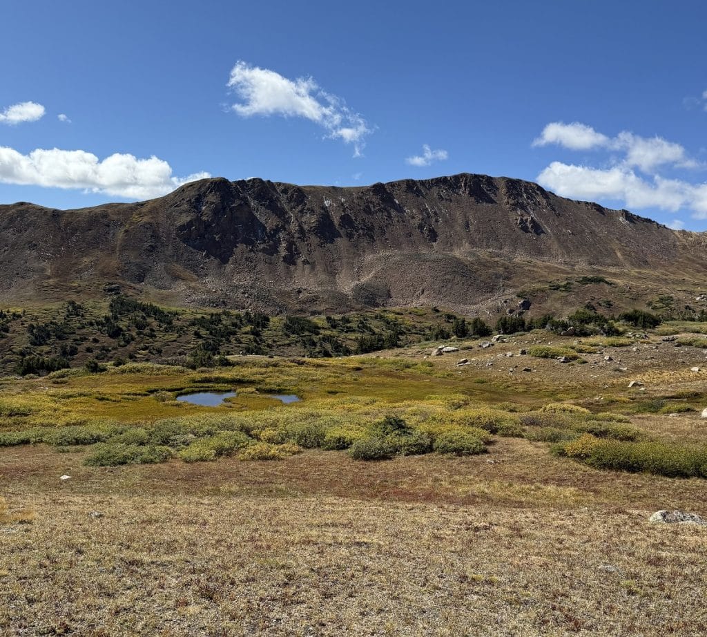 A lovely mountain scene with fall colors and blue sky.