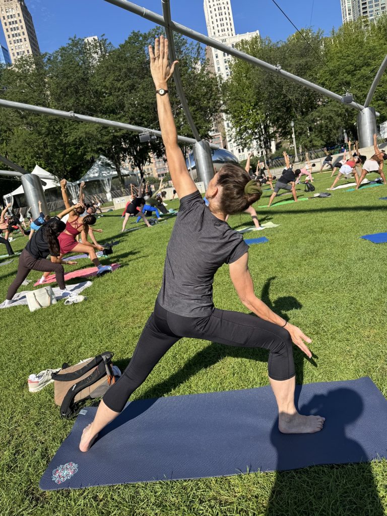 A woman reaches to the sky on a yoga mat.