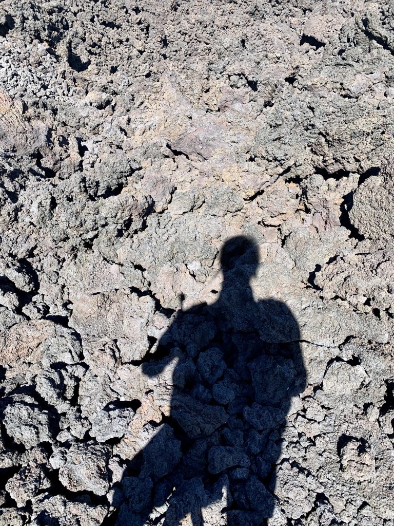 A shadow of the photographer is shown on a rugged trail.