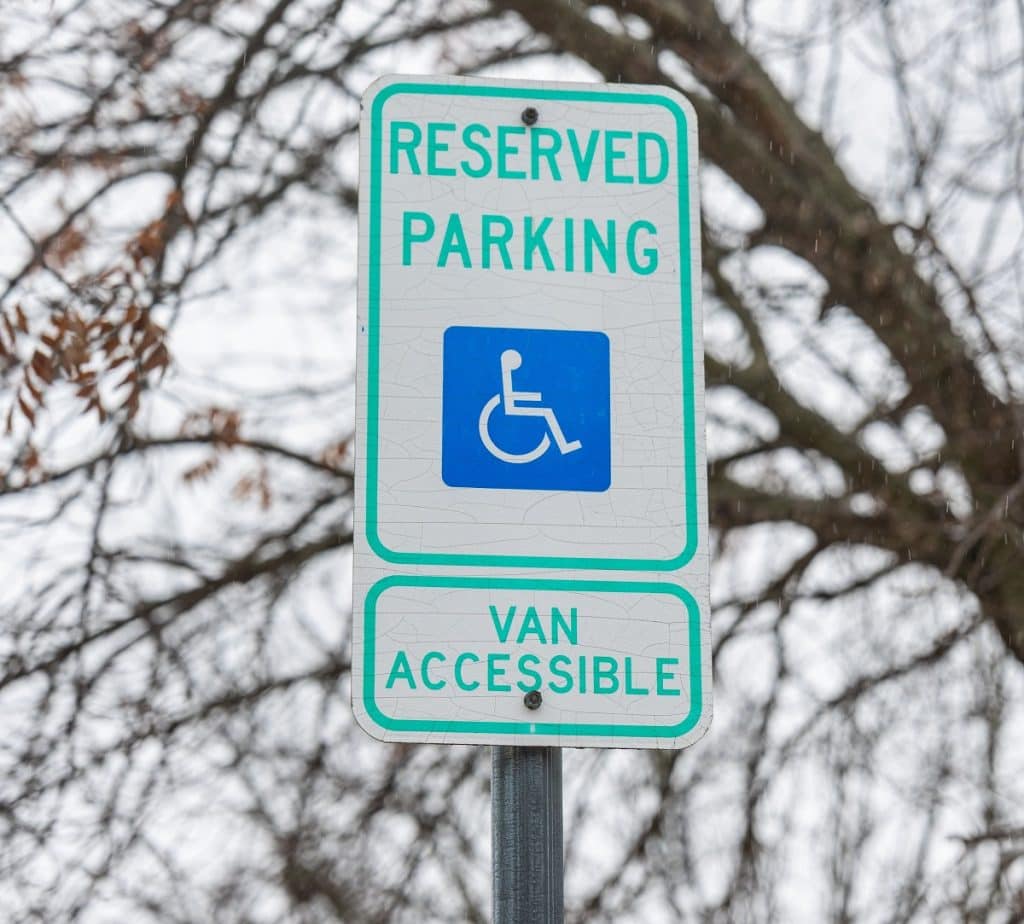 A sign issues a warning over a handicapped parking space.