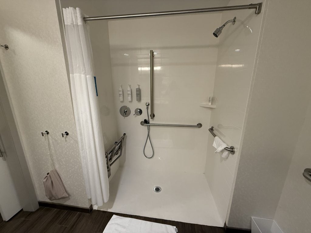 A handicapped accessible bathroom has bars and safety features.