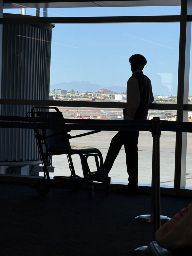 A silouette of a man at a window wiith a wheelchair.