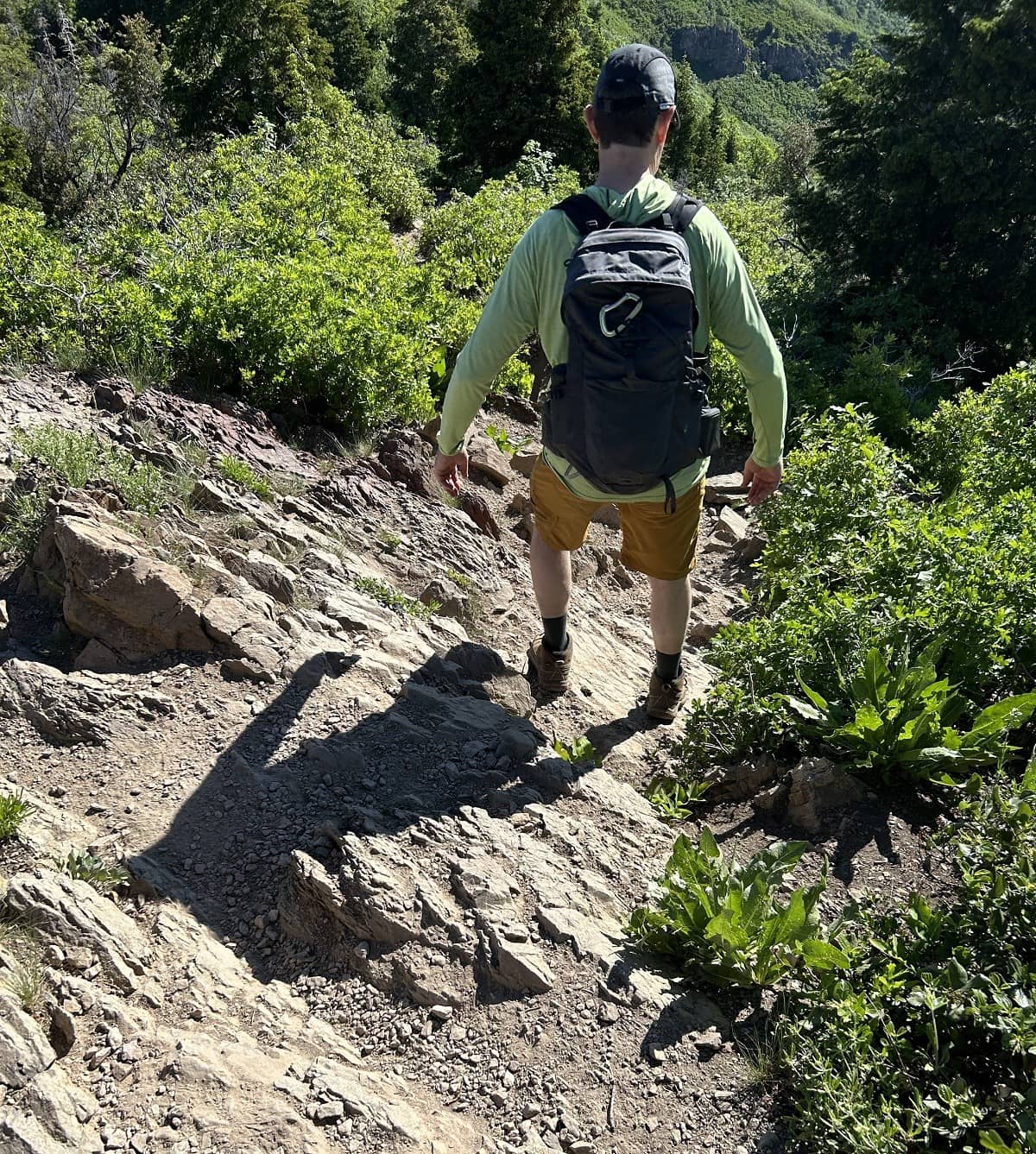 A hiker climbs down over rocks.