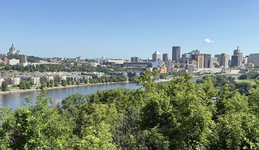 A sweeping view of a downtown with the river running in the foreground.